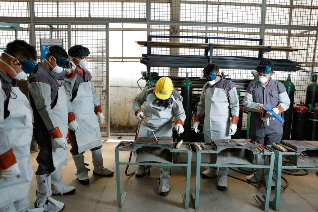 Group of workers in protective gear engaged in factory training in the Philippines.
